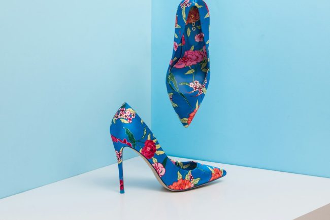 Luxury designer leather slingbacks and soft suede loafers displayed on stone plinth