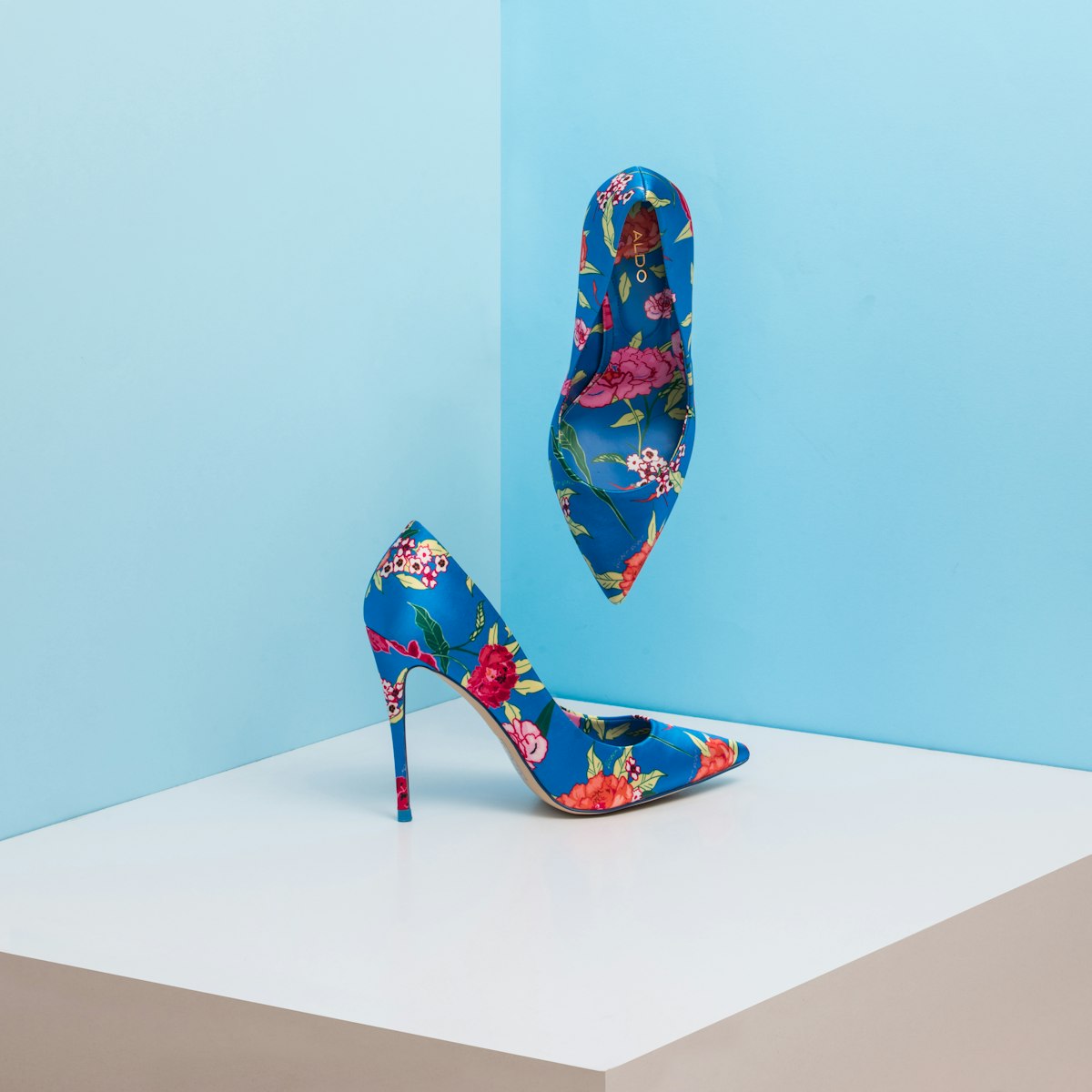 Luxury designer leather slingbacks and soft suede loafers displayed on stone plinth