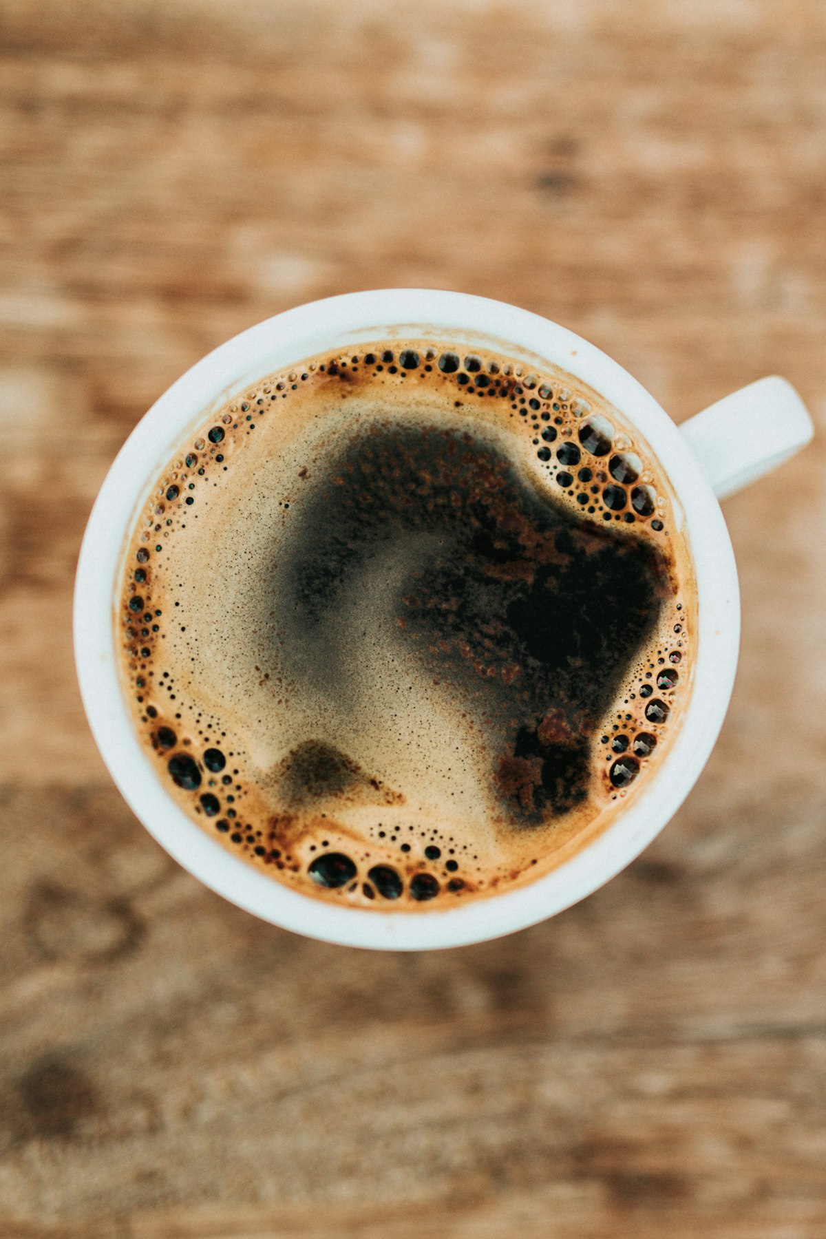 Commercial-grade chrome espresso machine extracting rich hazelnut crema into ceramic cup