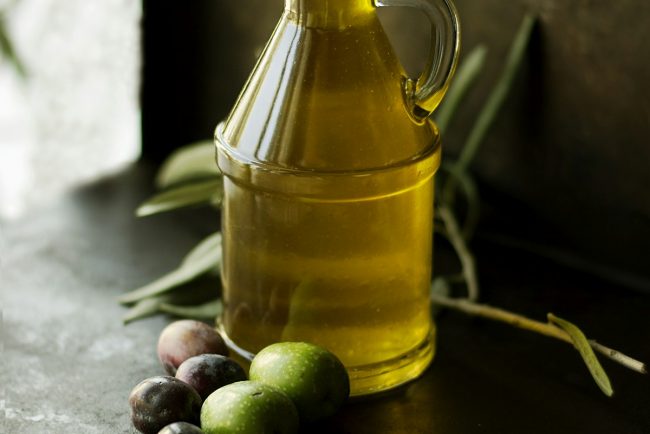Golden green single-estate extra virgin olive oil drizzled gracefully over rustic artisan sourdough