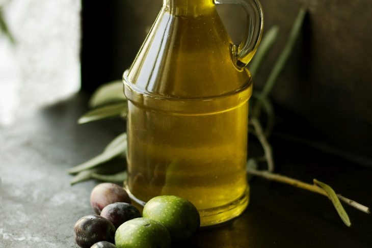 Golden green single-estate extra virgin olive oil drizzled gracefully over rustic artisan sourdough
