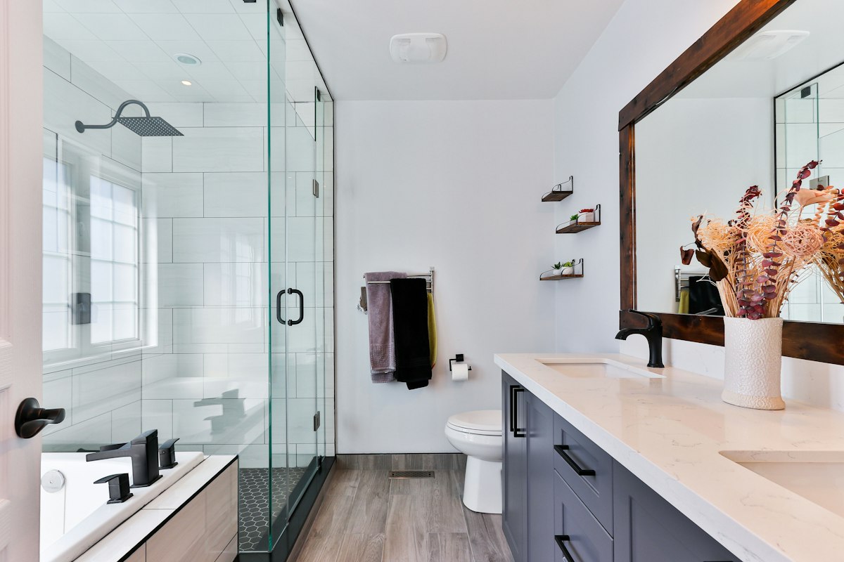 Architectural freestanding composite stone soaking tub in sun-drenched minimalist marble master bath