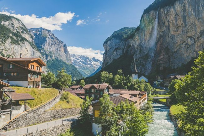 Iconic red luxury train winding through dramatic Swiss Alps mountain pass